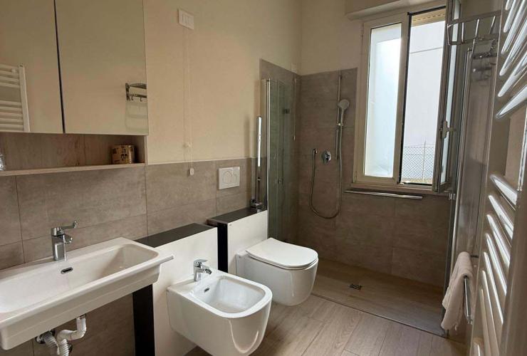 Bagno moderno e luminoso, con doccia spaziosa e arredi eleganti in tonalità neutre.